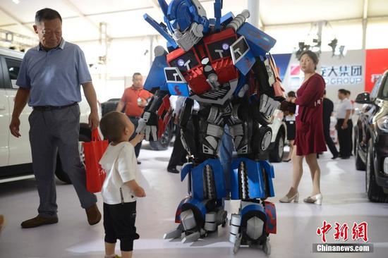 6月30日，車展上的“變形金剛”為主辦方造勢(shì)。當(dāng)日，2016第八屆呼和浩特國際汽車展覽會(huì)開幕，展會(huì)為期5天，國內(nèi)外近80個(gè)汽車品牌以及30多家汽配商企參展，同時(shí)還設(shè)有汽保、老爺車、金融、改裝以及汽車行業(yè)相關(guān)服務(wù)等展示區(qū)，參展車型近500余款。中新社記者